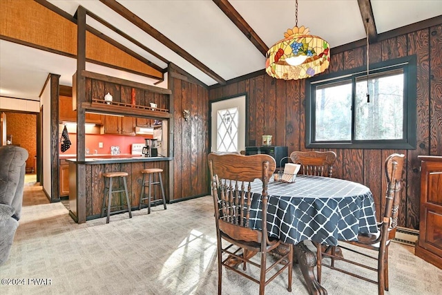 carpeted dining room featuring bar area, vaulted ceiling with beams, and wood walls