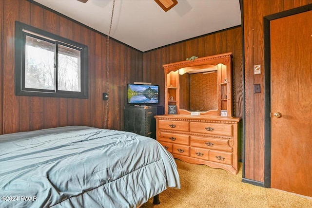 carpeted bedroom with ceiling fan and wood walls