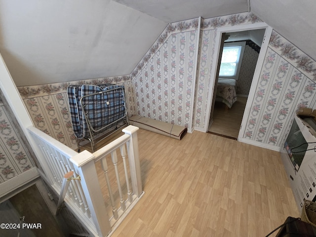 bonus room with wood-type flooring and vaulted ceiling