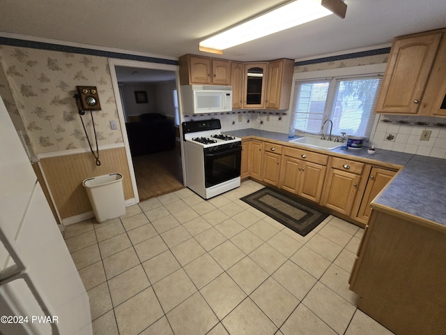 kitchen featuring sink, wooden walls, white appliances, decorative backsplash, and light tile patterned floors