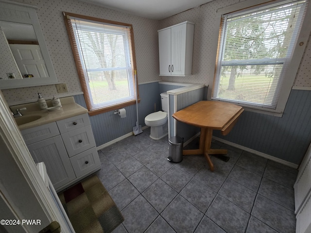 bathroom featuring wooden walls, tile patterned flooring, and toilet