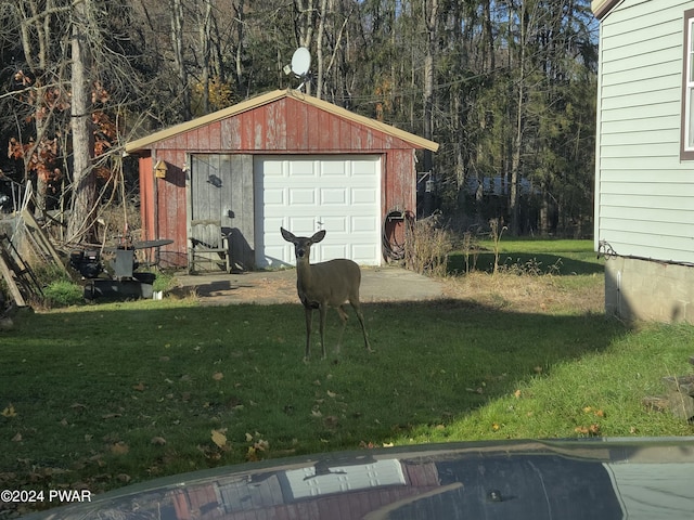 view of outdoor structure with a yard and a garage