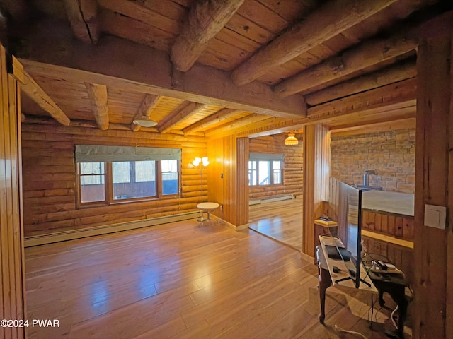 interior space with wooden ceiling, rustic walls, baseboard heating, beam ceiling, and wood-type flooring