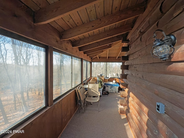 unfurnished sunroom with lofted ceiling with beams, plenty of natural light, and wooden ceiling