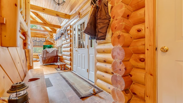 interior space with lofted ceiling with beams, wooden ceiling, tile patterned flooring, and rustic walls