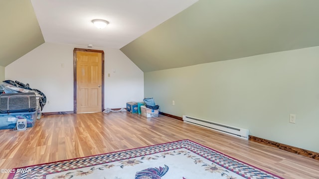 additional living space featuring baseboards, a baseboard radiator, wood finished floors, and lofted ceiling