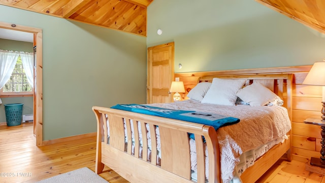 bedroom featuring wood-type flooring, lofted ceiling with beams, wooden ceiling, and baseboard heating