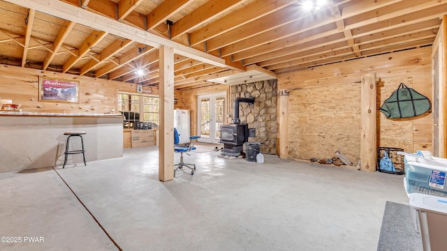 basement with a wood stove and fridge