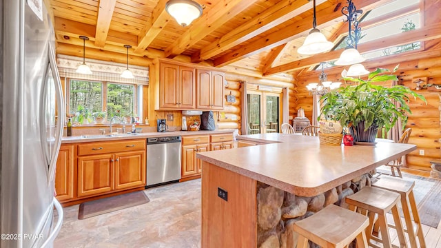 kitchen featuring a sink, wood ceiling, rustic walls, and stainless steel appliances