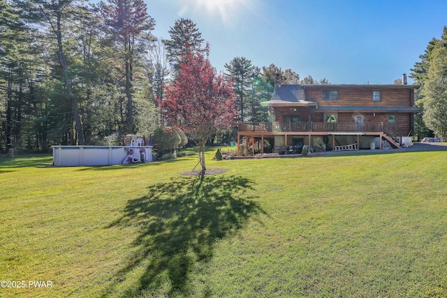 view of yard featuring stairway, a deck, and an outdoor pool