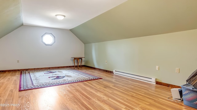 additional living space featuring baseboards, baseboard heating, vaulted ceiling, and wood finished floors