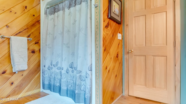 full bath with baseboards, curtained shower, and wood finished floors