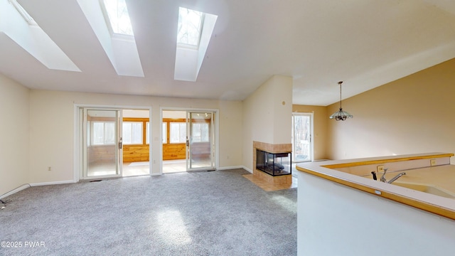 unfurnished living room with a tile fireplace, a skylight, and a wealth of natural light