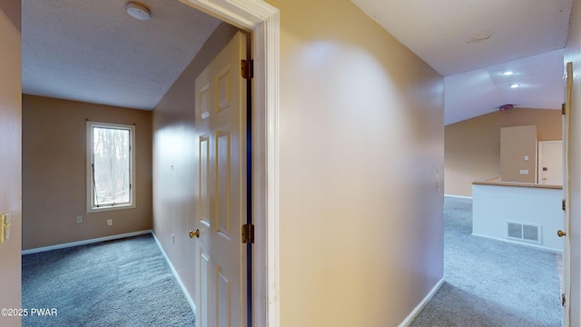 corridor with vaulted ceiling and light carpet