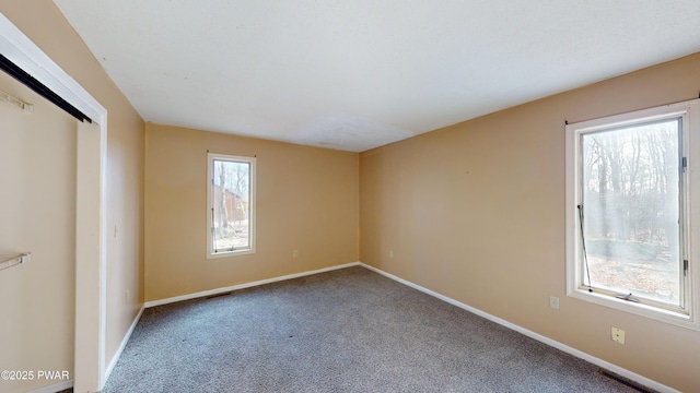 carpeted spare room featuring plenty of natural light