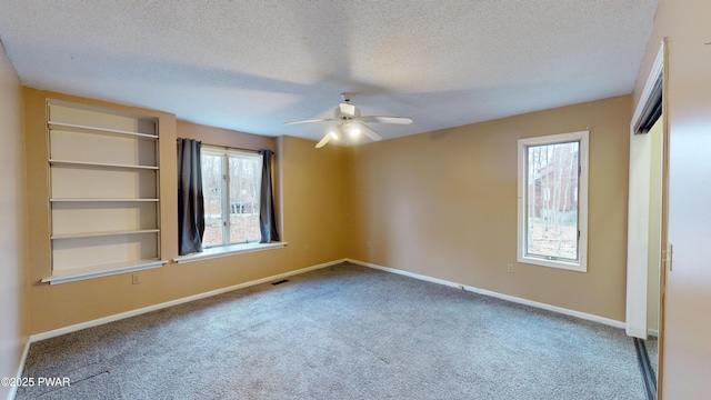 empty room with a textured ceiling, ceiling fan, and carpet flooring