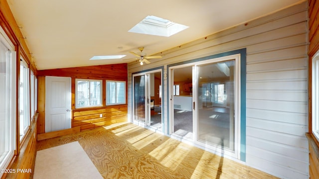 unfurnished sunroom featuring ceiling fan and lofted ceiling with skylight