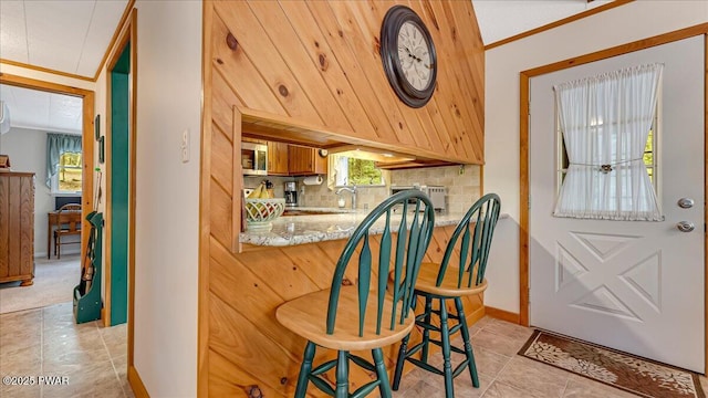 32 White Oak Dr, Lakeville, PA 18438 - bar area with stainless steel microwave, decorative backsplash, light tile patterned floors, a sink, and ornamental molding