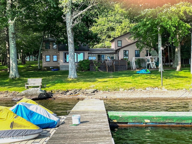 dock area featuring a deck with water view and a lawn