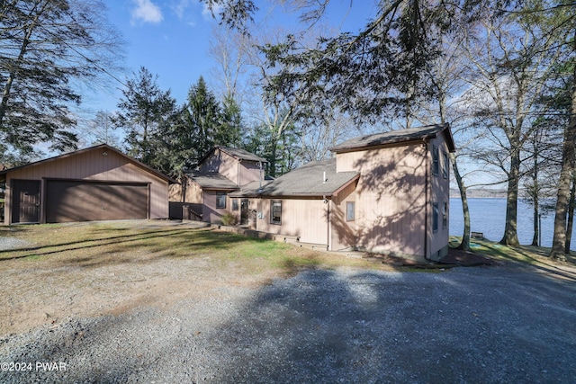 view of property exterior featuring an outbuilding, a water view, and a garage