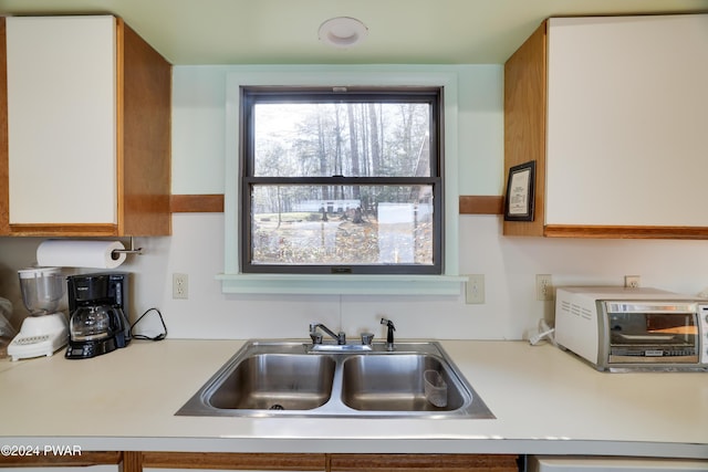 kitchen featuring white cabinetry and sink