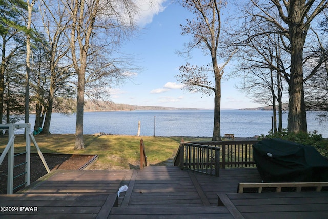 wooden terrace featuring a water view and area for grilling