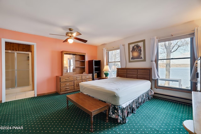 carpeted bedroom with baseboard heating, ceiling fan, and a water view