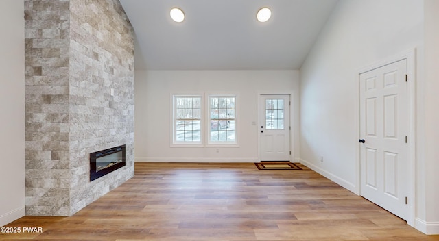 209 Bindale Rd, Tamiment, PA 18324 - unfurnished living room featuring a fireplace, wood finished floors, baseboards, and high vaulted ceiling