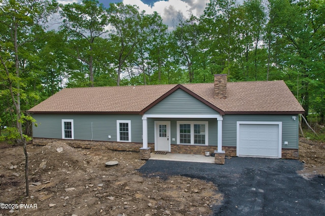 209 Bindale Rd, Tamiment, PA 18324 - single story home with an attached garage, a shingled roof, a chimney, and stone siding