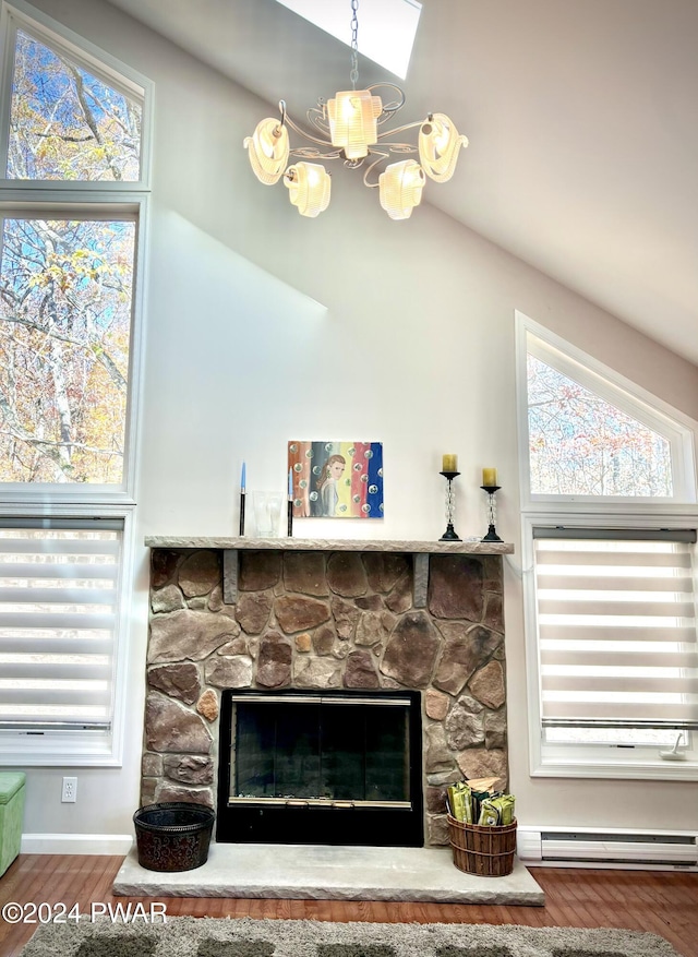 room details with a fireplace, a baseboard radiator, hardwood / wood-style flooring, and a chandelier