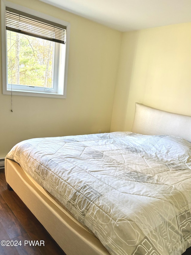 bedroom with dark hardwood / wood-style floors