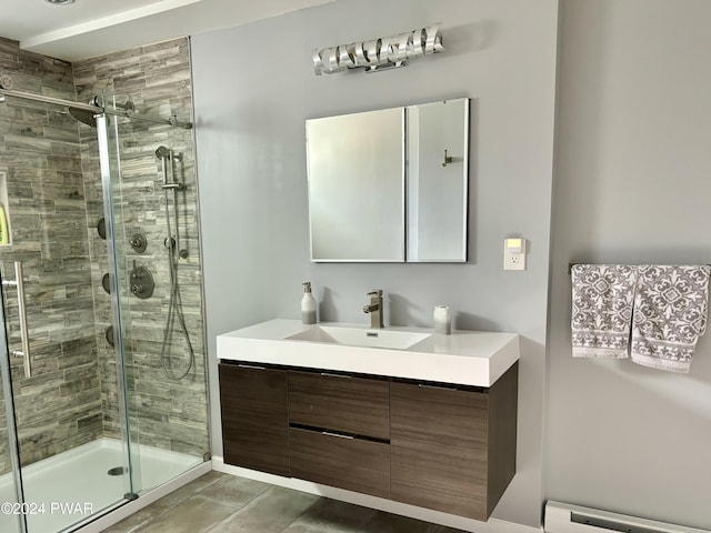 bathroom featuring tile patterned floors, vanity, an enclosed shower, and baseboard heating