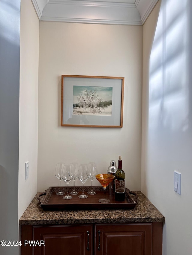 interior space featuring bar area and crown molding