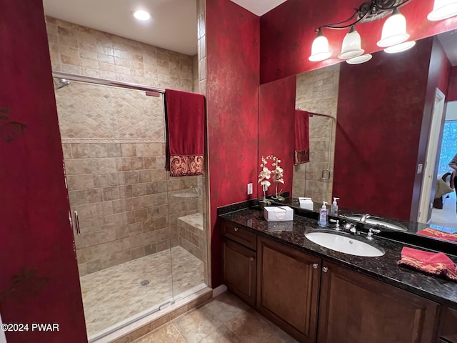 bathroom with tile patterned floors, a shower with door, and vanity