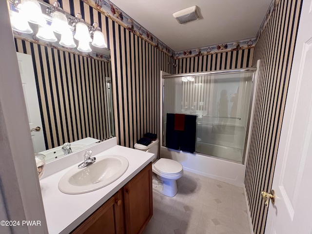 full bathroom with shower / bath combination with glass door, vanity, and toilet