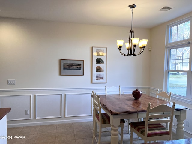 tiled dining area featuring an inviting chandelier