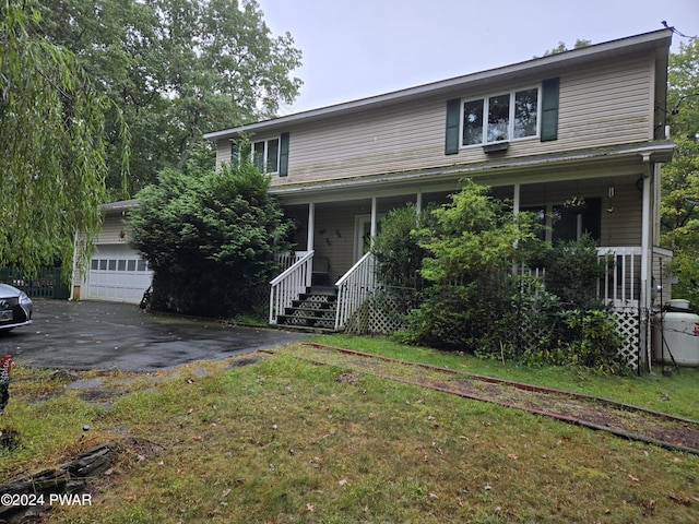 view of front facade featuring covered porch, a garage, an outdoor structure, and a front yard