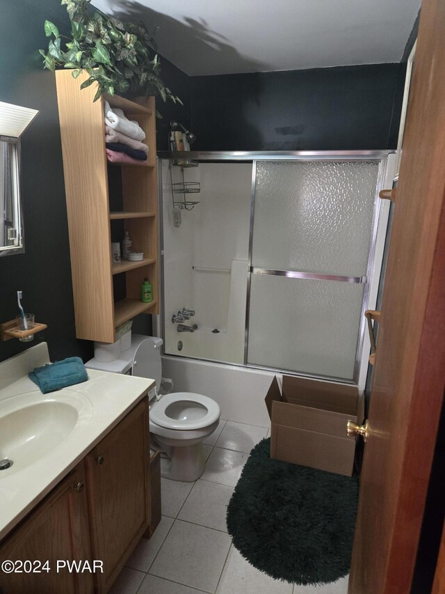 full bathroom featuring shower / bath combination with glass door, vanity, tile patterned floors, and toilet