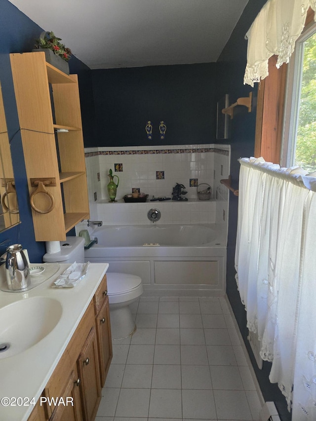 bathroom with tile patterned flooring, vanity, a tub to relax in, and toilet