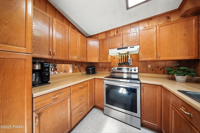 201 Oak Hill Rd, Hawley, PA 18428 - kitchen with stainless steel electric stove, under cabinet range hood, light countertops, brown cabinets, and wooden walls