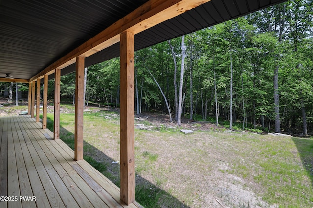 wooden deck with a lawn and ceiling fan