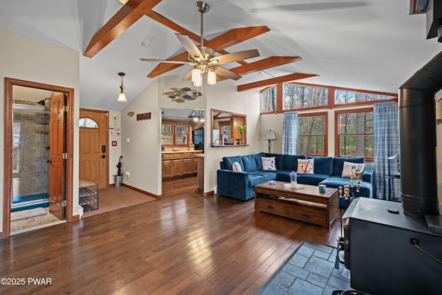 135 Outer Dr, Dingmans Ferry, PA 18328 - living area with a wood stove, a ceiling fan, dark wood finished floors, beam ceiling, and baseboards