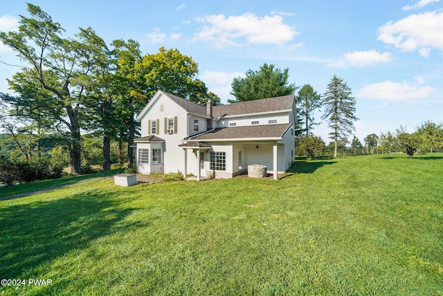 rear view of house featuring a yard