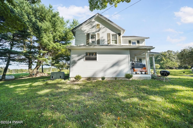 view of home's exterior with a porch, central air condition unit, and a lawn