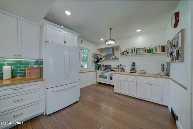 kitchen featuring white cabinetry, wall chimney range hood, backsplash, pendant lighting, and white appliances