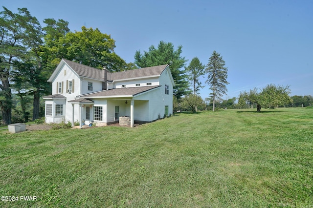 rear view of house featuring a yard