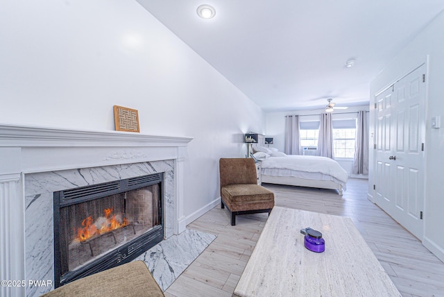 bedroom with a fireplace and light wood-type flooring