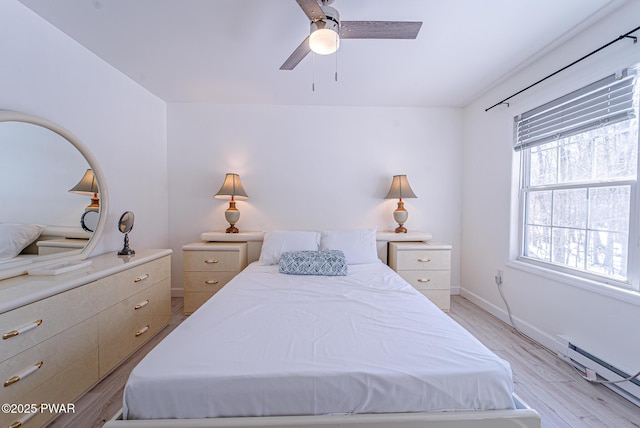 bedroom with ceiling fan, baseboard heating, and light hardwood / wood-style flooring