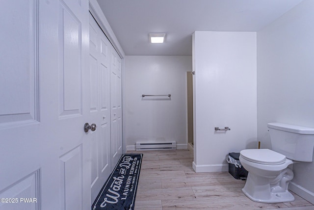 bathroom with a baseboard heating unit, hardwood / wood-style floors, and toilet