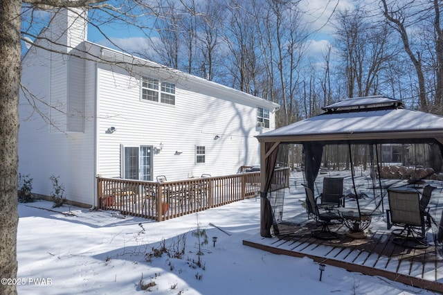 snow covered rear of property featuring a gazebo and a wooden deck